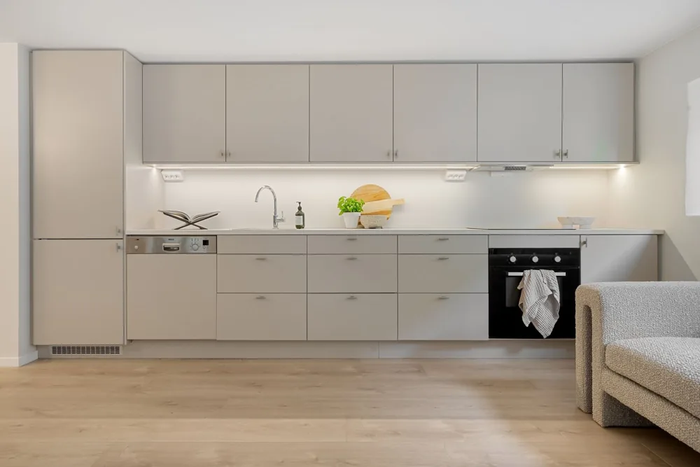 Illustrative complete kitchen with light cabinetry, integrated appliances and wood flooring